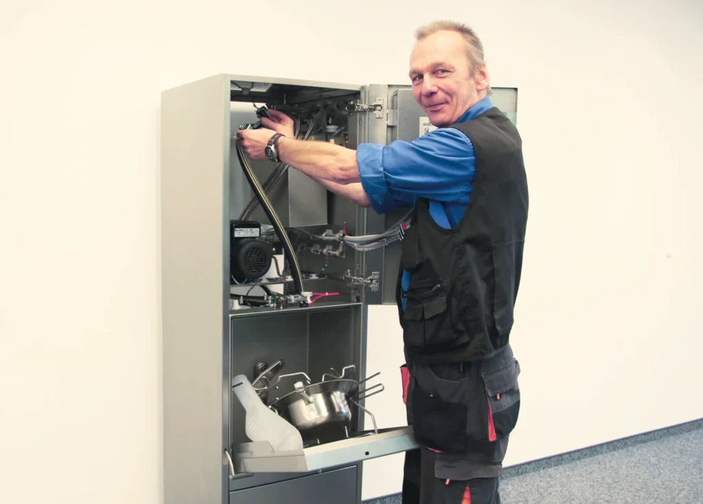 DISCHER Servicetechniker bei der Wartung einer geöffneten Fäkalspüle