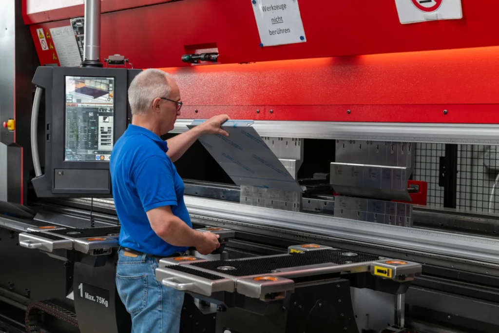DISCHER Mitarbeiter bedient eine Abkantpresse in der Produktion
